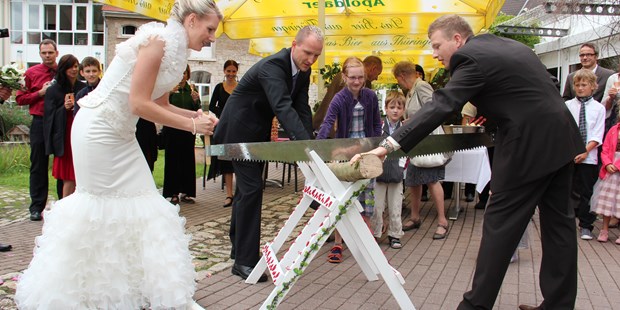 Destination-Wedding - Preisniveau Hochzeitsfeier: €€ - Traditionelles Holzsägen auf der Hotelterrasse  - Hotel am Schloß Apolda