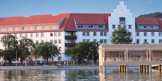 Destination-Wedding - Art der Location: Hotel / Chalet - Vorarlberg - Blick auf das Seehotel mit dem Badehaus im Vordergrund - Seehotel am Kaiserstrand