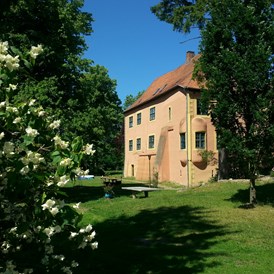 Hochzeitslocation: Burg vom Park aus mit Jasmin-Sträuchern - Wasserburg Turow