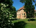 Hochzeitslocation: Burg vom Park aus mit Jasmin-Sträuchern - Wasserburg Turow