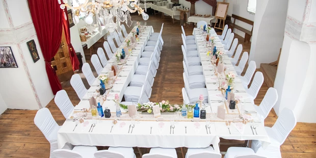 Destination-Wedding - Art der Location: Hotel / Chalet - Blick von oben auf die Hochzeitstafel in der Kapelle - Burg Plankenstein