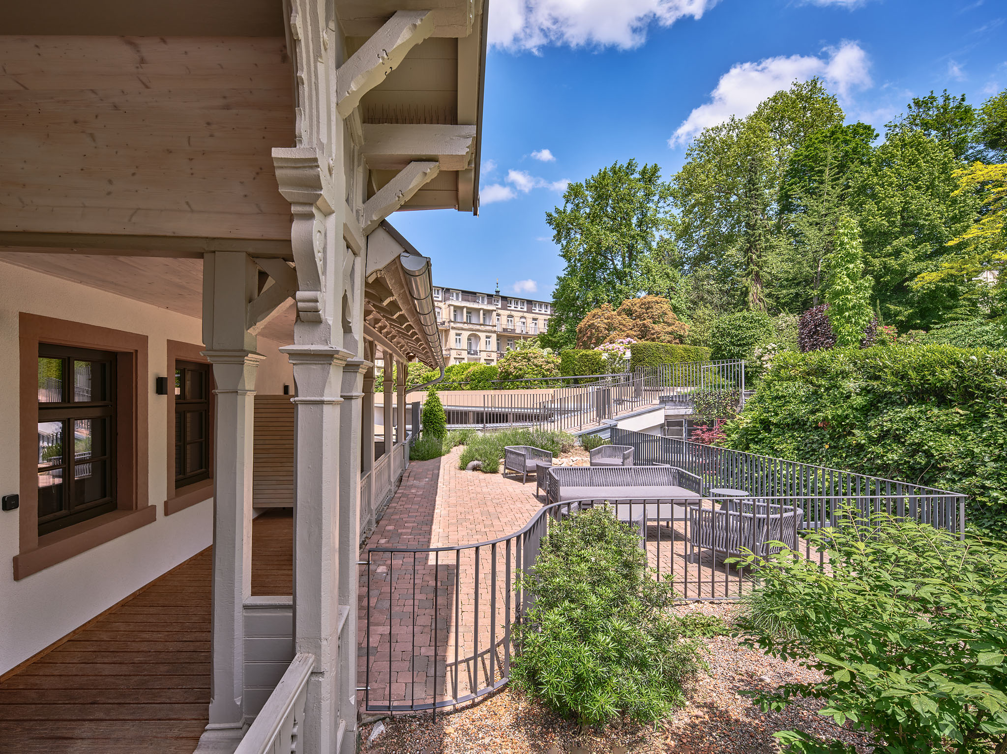 Destination-Wedding - Schwarzwald - Auf dem Foto blickt man von der Veranda der Hotel am Sophienpark Dependance über den Hotelpark zum Haupthaus. Auf der Terrasse des historischen Schweizerhauses lassen sich die Sommerabende genießen. - Hotel am Sophienpark